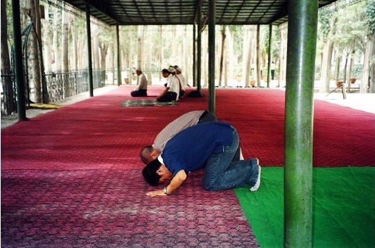 Ein Han-Chinese probiert unter uigurischer Anleitung das Gebet aus